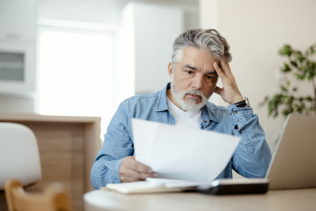 A worried middle-aged man confused and astonished by a high medical bill